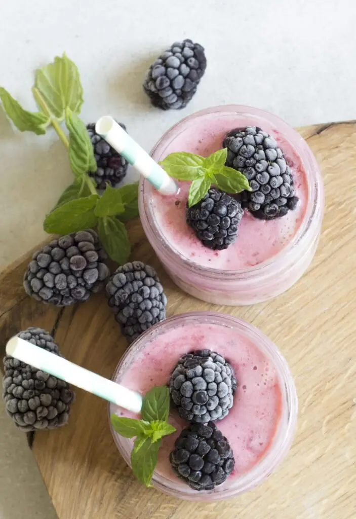 Enjoy a refreshing blackberry smoothie topped with fresh mint leaves, perfect for a summer treat.